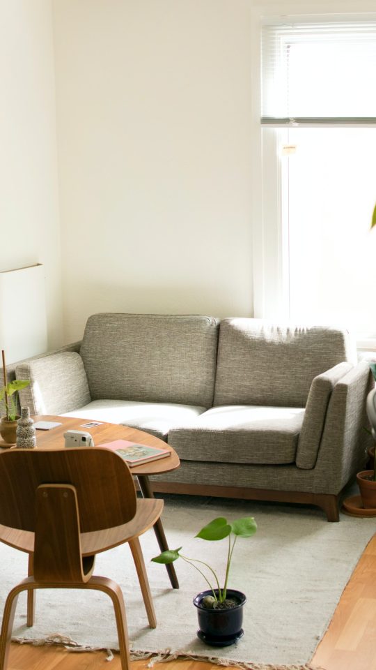 gray fabric loveseat near brown wooden table
